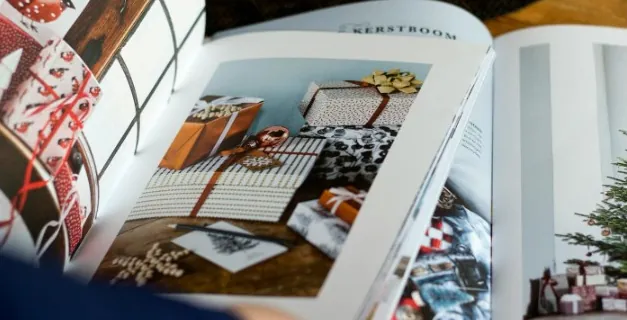 An open art book showing a photographed interior, lit from the side.